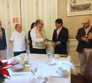 El maestro Raúl Gómez Espinoza entrega reconocimiento al Doctor Eber Omar Betanzos Torres. A la derecha el Maestro Israel González Delgado.